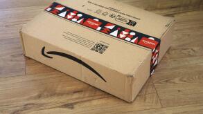 WARSAW, POLAND - DECEMBER 18, 2023: Amazon online store order box package delivered in Europe before Christmas, with holiday design tape.