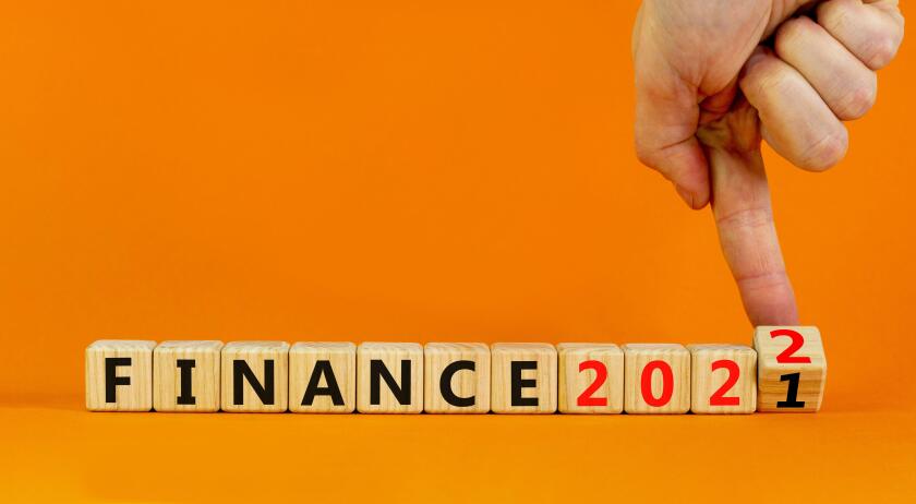 2022 finance and new year symbol. Businessman turns wooden cubes, changes words 'finance 2021' to 'finance 2022'. Beautiful orange background, copy sp