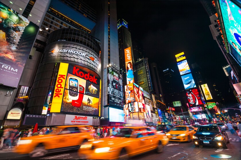 Traffic in Times Square at night with taxi cabs driving through the streets, New York City