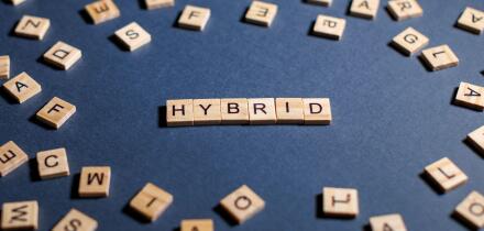 word hybrid on a dark background spelled with wooden letters