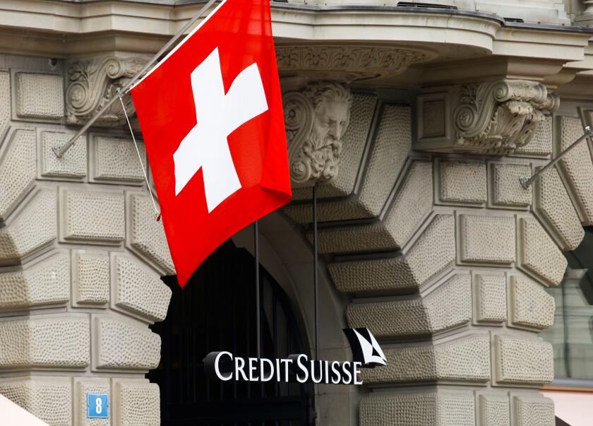 Switzerland's national flag flies above the logo of Swiss bank Credit Suisse at its headquarters in Zurich, Switzerland April 18, 2021. REUTERS/Arnd Wiegmann