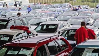 Buyers inspecting cars at a UK car auction