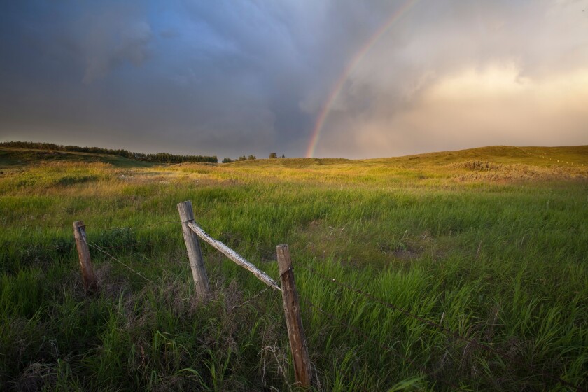 Rainbow and passing storm North of Calgary, Alberta, Canada.