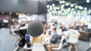 Microphone with abstract blurred photo of conference hall or seminar room with attendee and bokeh, Business meeting concept
