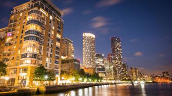 A skyline view of office and condominium towers along The Canary Wharf pier and neighbourhood at dusk.  The Thames River, London UK.