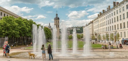 People enjoying the spring weather at the fountain of the Place Antonin Poncet in Lyon, France
