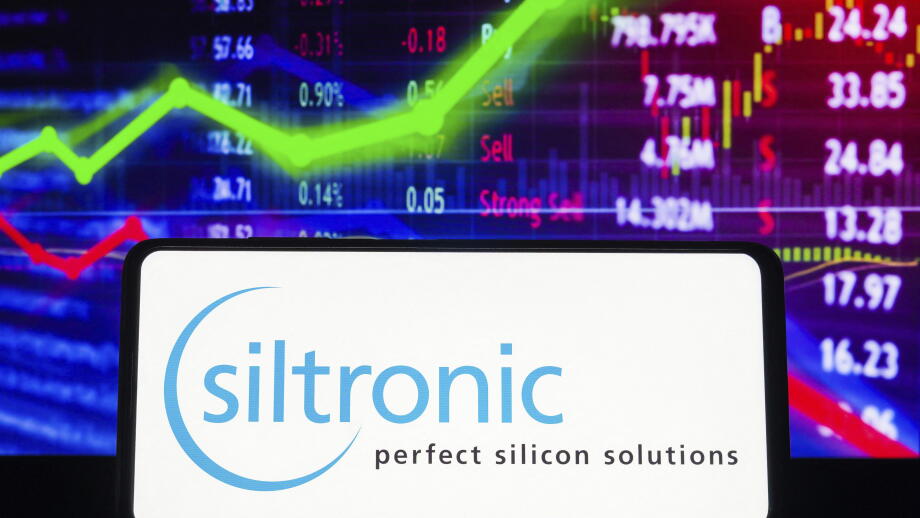 In this photo illustration the Siltronic AG logo seen displayed on a smartphone screen, with graphic representation of the stock market in the backgro