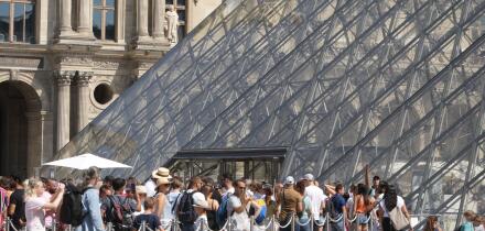 People wait line up near Pyramid at the Louvre Museum during a hot summer day with 30 degrees Celsius on August 25, 2022 in Paris,France.