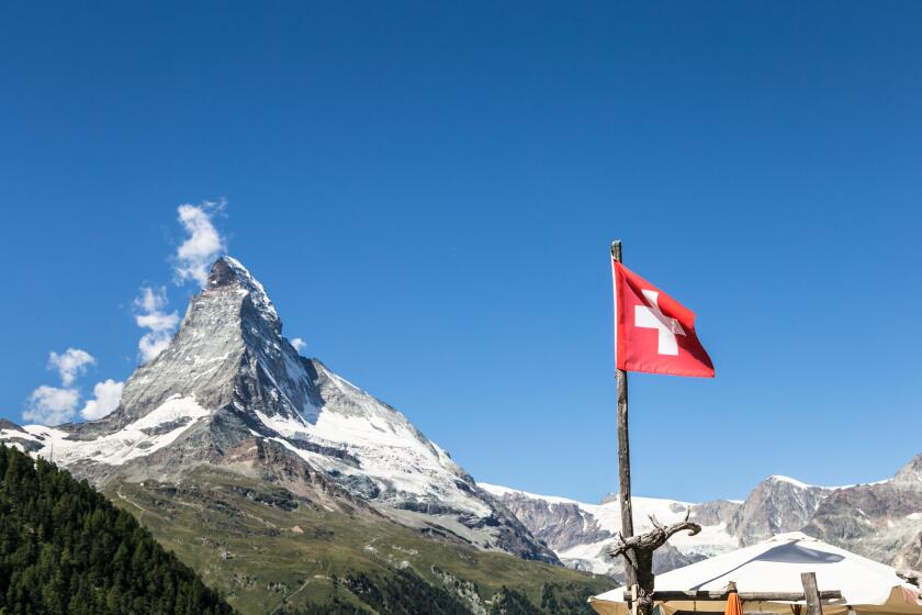 The Matterhorn and a Swiss flag above the famous village of Zermatt in Canton Valais in the alps in Switzerland