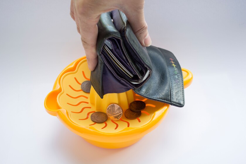 Budget Squeeze - Every last penny being squeezed out of a purse.