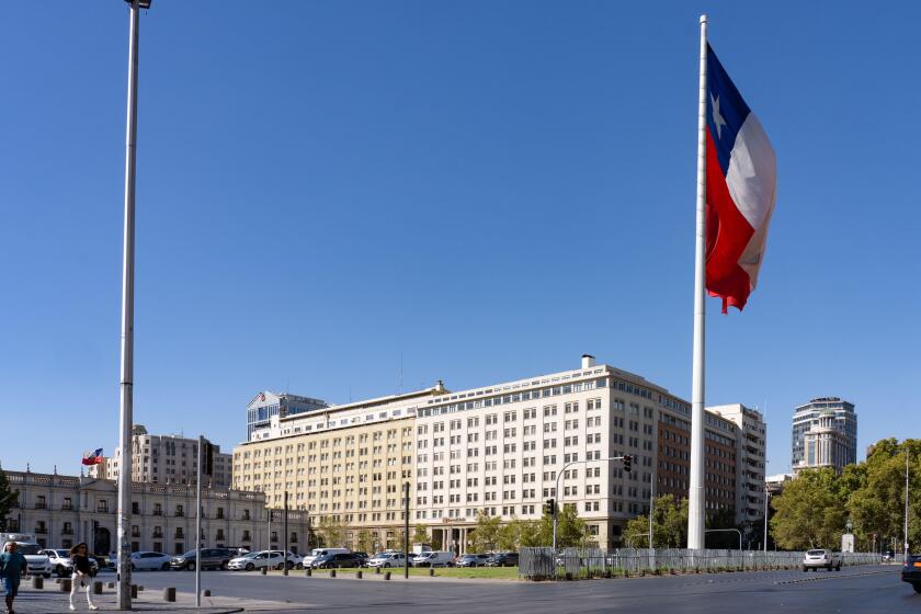 Huge Chilean flag in front of the La Moneda Palace, left, and the Banco Estado building in downtown Santiago, Chile.