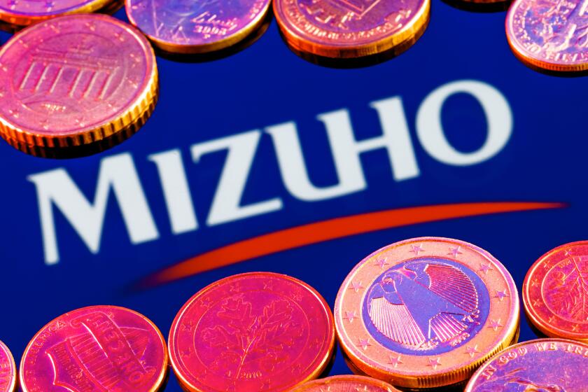 Variety of metal coins on background of Mizuho Financial Group logo
