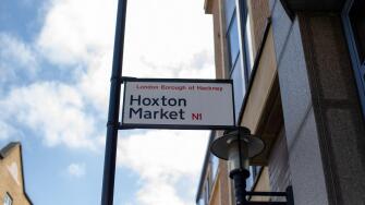 Street sign for Hoxton Market in the London Borough of Hackney under a clear sky.
