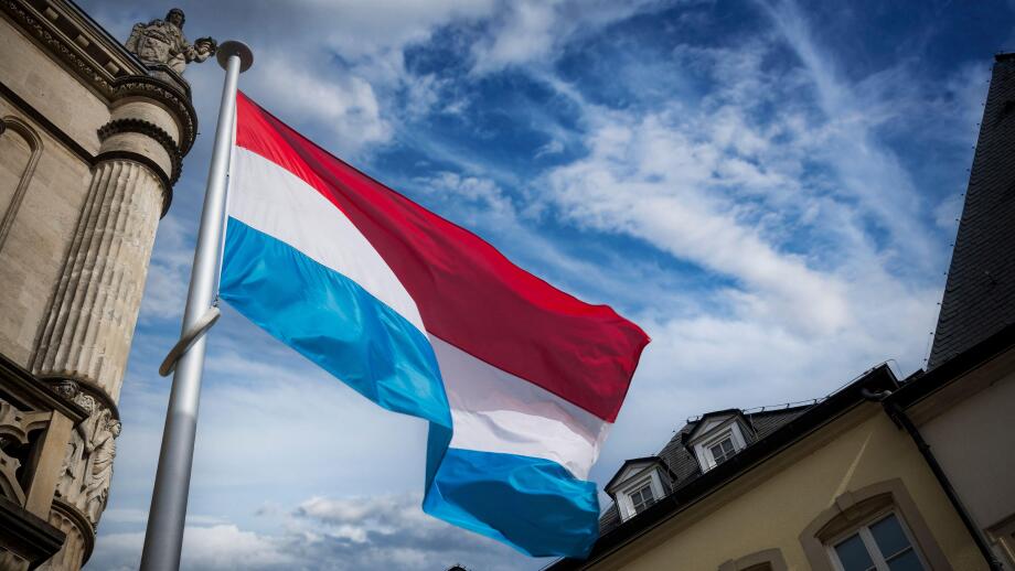 Luxembourg flag flying among historic buildings in the capital