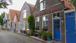 Quaint village houses with blooming flowers and plants in Edam, Netherlands, showcasing traditional Dutch architecture