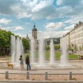 People enjoying the spring weather at the fountain of the Place Antonin Poncet in Lyon, France