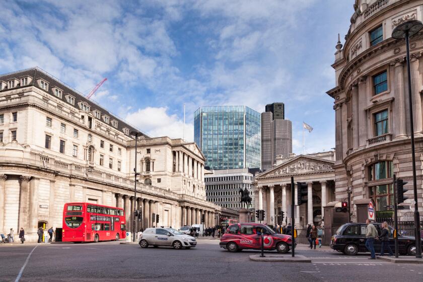 A street scene in Threadneedle Street, London, England, with the Bank of England on the left. The glass building is the...