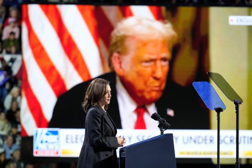 Democratic presidential nominee Vice President Kamala Harris speaks as an image of Republican presidential nominee former President Donald Trump appears on screen during a campaign rally at Erie Insurance Arena, in Erie, Pa., Monday, Oct. 14, 2024. (AP Ph