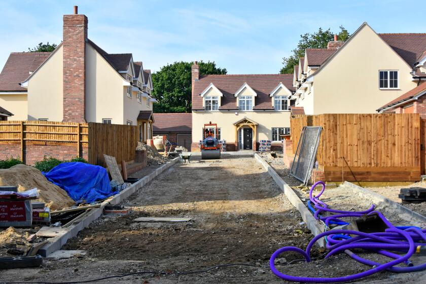 Building site for small new housing property development nearing completion with kerbs garden fences and road foundations in progress Essex England UK