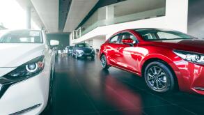 New cars parked in luxury showroom. Car dealership office. Car parked in showroom with care. Car for sale and rent business. Automobile leasing market. Electric vehicle. EV car dealer agent company.