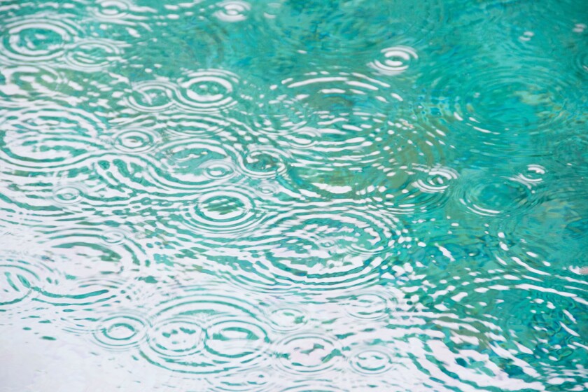 Brazil, Bahia, Trancoso, Raindrops on falling on pond surface