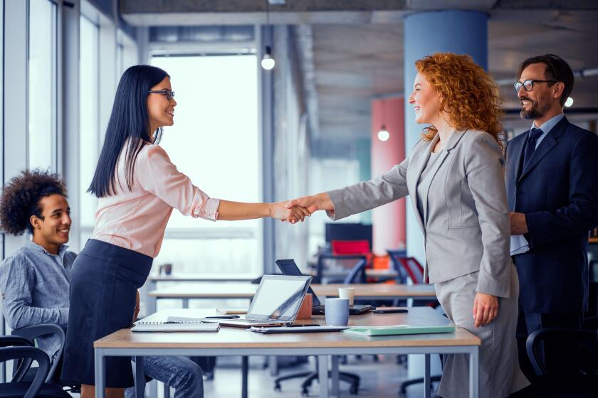 Two businesswomen shaking hands.
