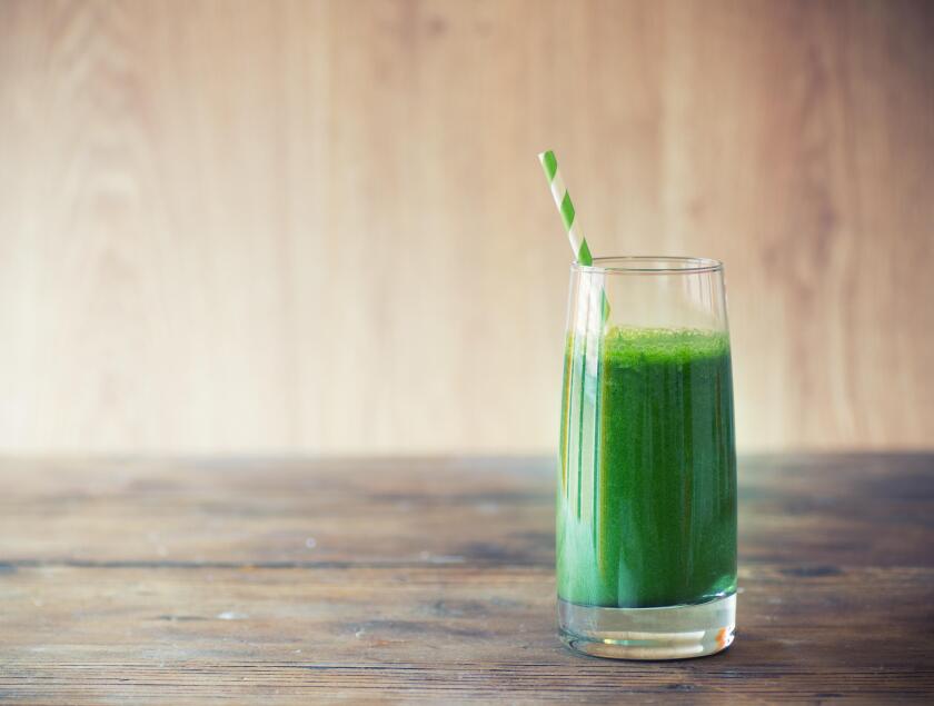 Green smoothie on vintage wooden background