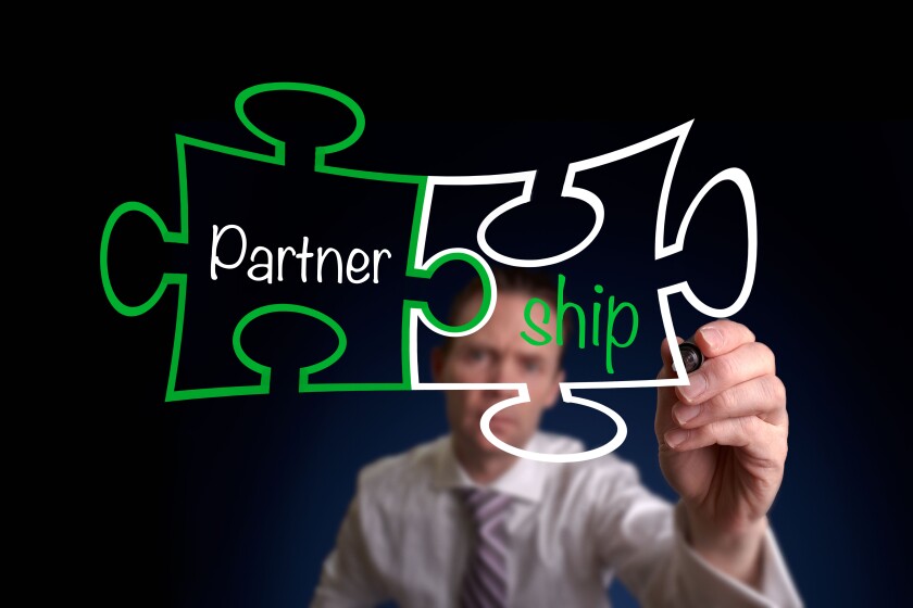 A businessman drawing a Partnership Puzzle Concept.