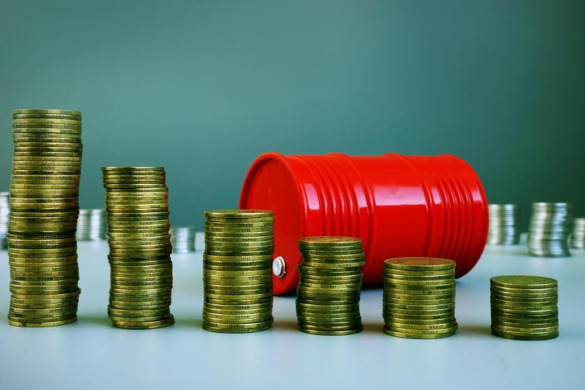 Oil price drop. Red barrel and money.