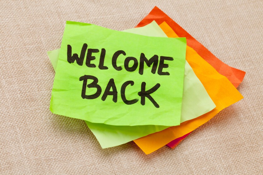 welcome back - handwriting on a green sticky note against canvas board