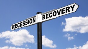 Signpost with the words Recession and Recovery against a blue cloudy sky