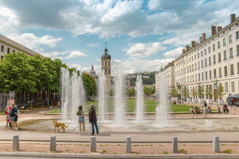 People enjoying the spring weather at the fountain of the Place Antonin Poncet in Lyon, France