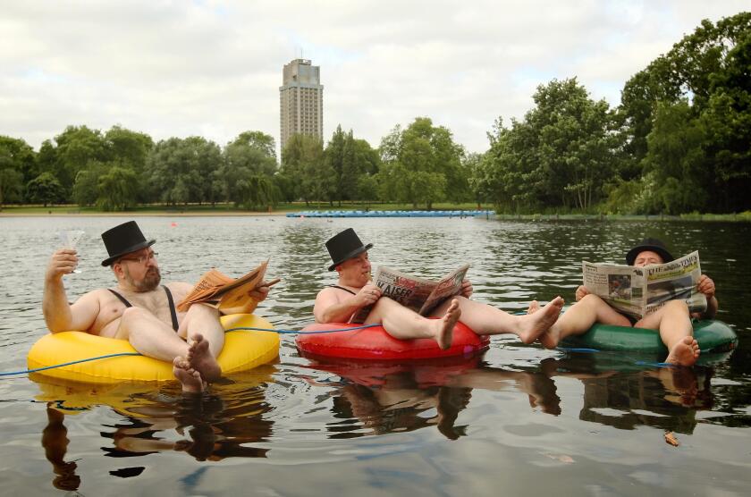 Businessmen dressed in mankinis float on rubber rings on the Serpentine in Hyde Park, central London, during a photocall for new 'community led' mobile phone company giffgaff.