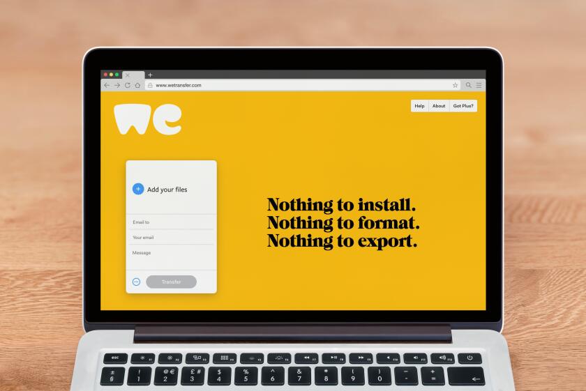 An Apple Macbook displays the WeTransfer website (Editorial use only).