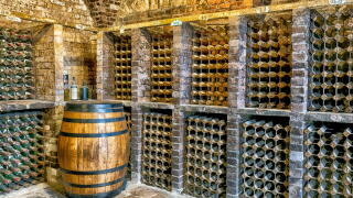 Traditional wine cellar featuring brick vaulted ceilings and stone flooring at Kingston Lacy country house, Kingston Lacy, Dorset, England, UK