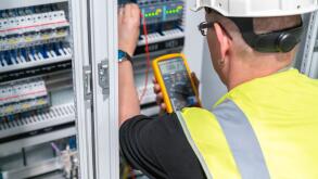 electrical engineer performs a measurement in a control cabinet