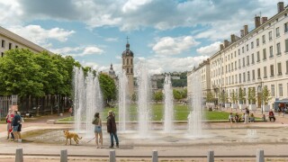 People enjoying the spring weather at the fountain of the Place Antonin Poncet in Lyon, France