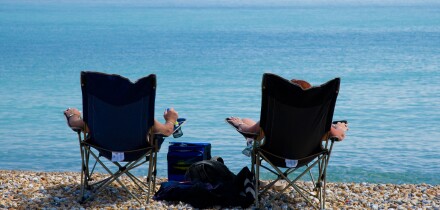 Two people soak up the sun on the beach