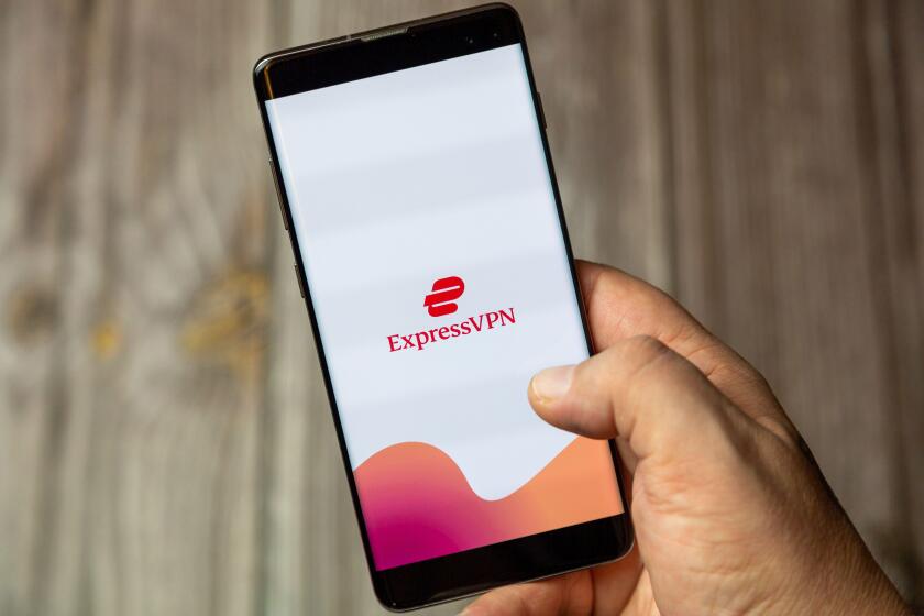 A mobile phone or cell phone being held by a hand with the Express VPN app open on screen