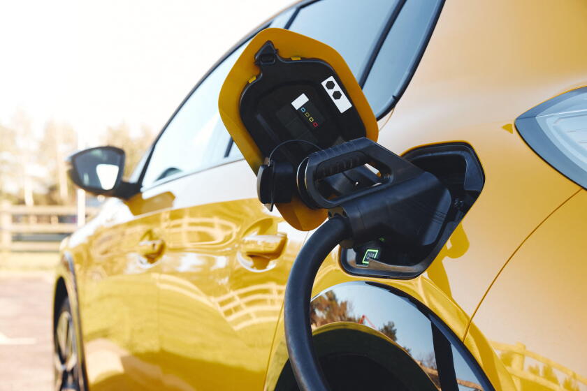 Close up of power supply plugged into an electric car being charged using a rapid charger cable