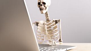 Job burnout. Skeleton sitting at table with laptop. Computer geek. Person suffering from stress at work. Mental and physical exhaustion, fatigue. High quality photo