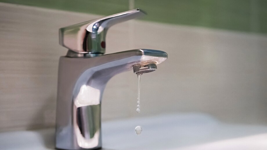 Traditional silver tap dripping. Broken faucet in the tub dripping water. Leaking plumbing. Wasteful water consumption. the concept of saving water.