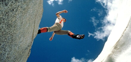A hiker jumps over a crevasse on a glacier high in the Canadian Rockies in Banff National Park. Image shot 2003. Exact date unknown.