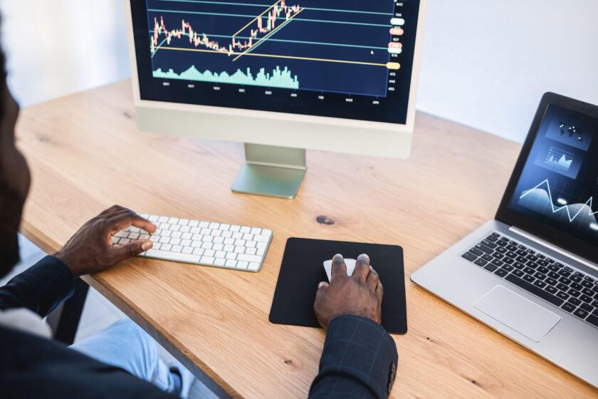 African trader studying stock market at home - Focus on right hand