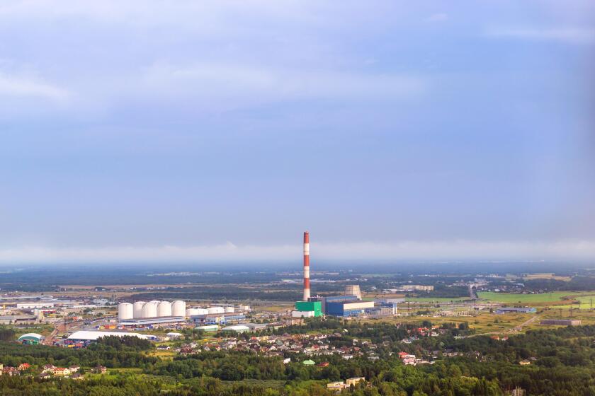 View from heights of Tallinn TV tower on Iru power plant, Eesti Energia. Types and horizons of Baltic cities with altitude. Cloudy overcast sky and ha