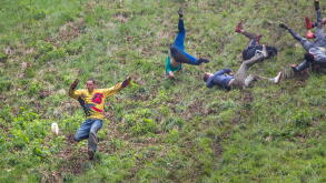 Gloucester, UK. The annual cheese rolling race held at Coopers Hill, Brockworth outside Gloucester. Competitors race down the extremly steep slippery hill chasing a double Gloucester cheese, the winner of each race recieves the cheese as thier prize.