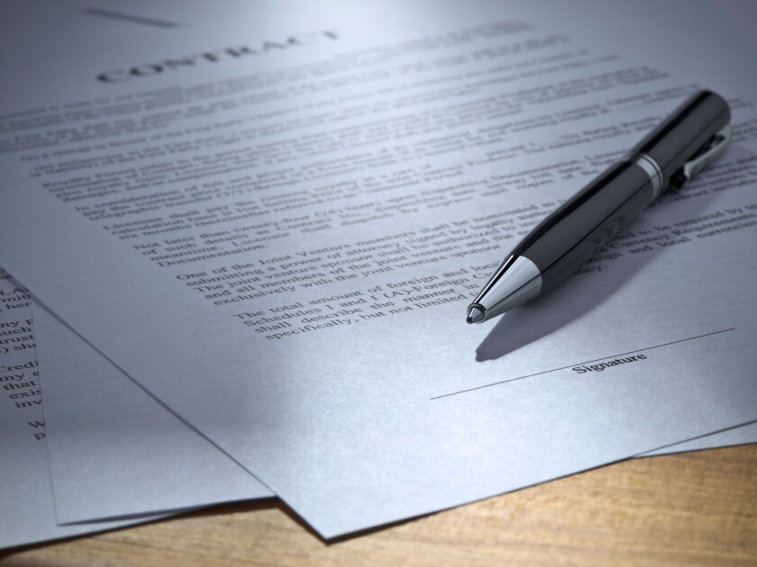 Close up of a pen over a contract to be signed.