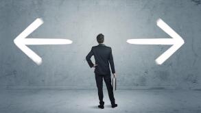 A businessman in doubt, having to shoose between two different choices indicated by arrows pointing in opposite direction concept