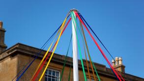 Colourful ribbons of maypole in front of cotswold stone building, Chipping Campden, Gloucestershire, England, United Kingdom, Europe
