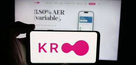 Stuttgart, Germany - 10-08-2025: Person holding cellphone with logo of British financial company Kroo Bank Ltd. on screen in front of webpage.